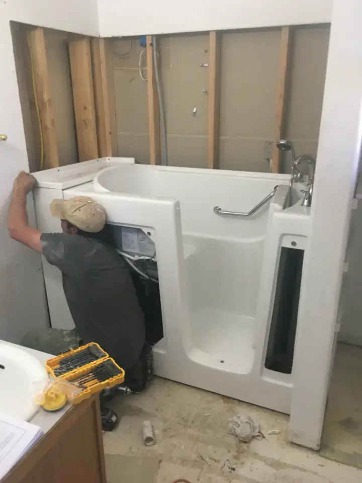 Installer fitting a walk-in tub into a bathroom (Walk-in tub installation in Utah)